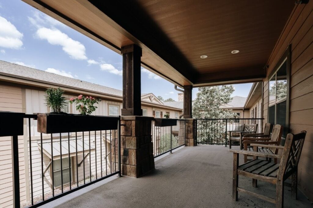 Covered Outdoor Balcony With Seating at Assisted Living Facility